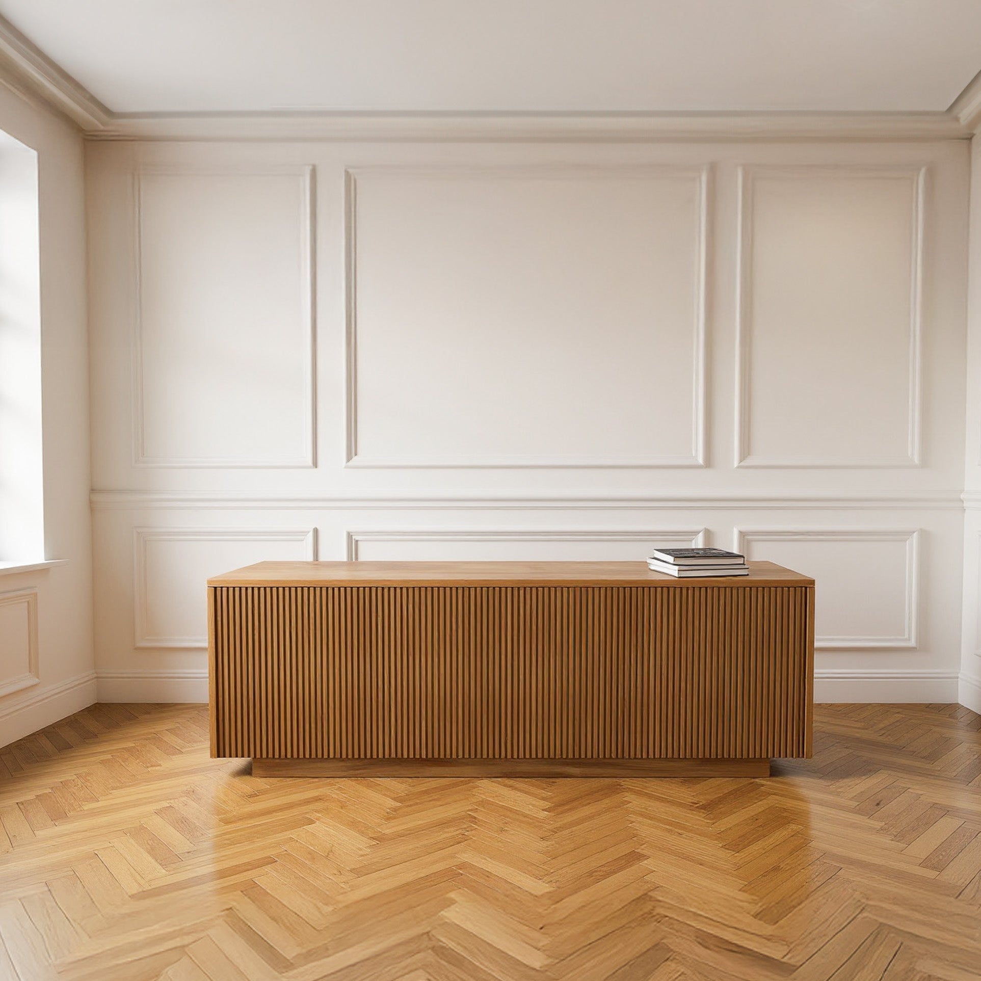 Wooden desk in a room with white paneled walls and wooden floor.