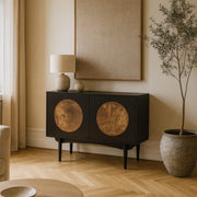 Black cabinet with circular designs in a living room setting